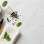 Anti-inflammatory acne remedies at home including aloe vera gel, green tea, and a niacinamide serum bottle on a marble surface