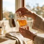 Best luxury perfumes for women shown in a faceted glass bottle held in morning light