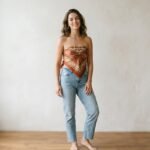 Woman wearing a silk scarf tied into a strapless top with high-waisted jeans